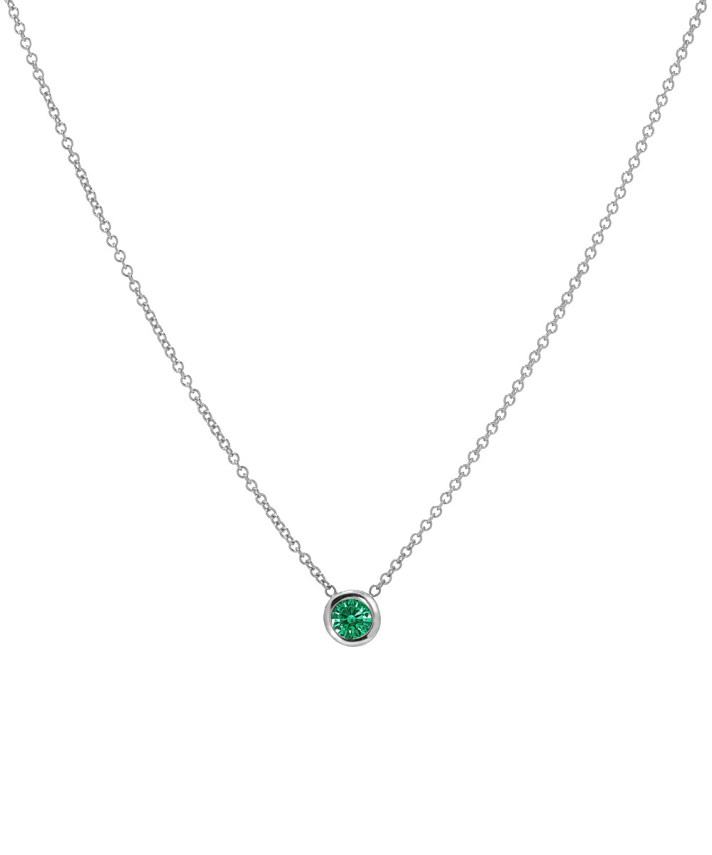 The 14KT White Gold 3 mm Bezel Solitaire Necklace features a single round green gemstone in a simple bezel setting, displayed on a white background.
