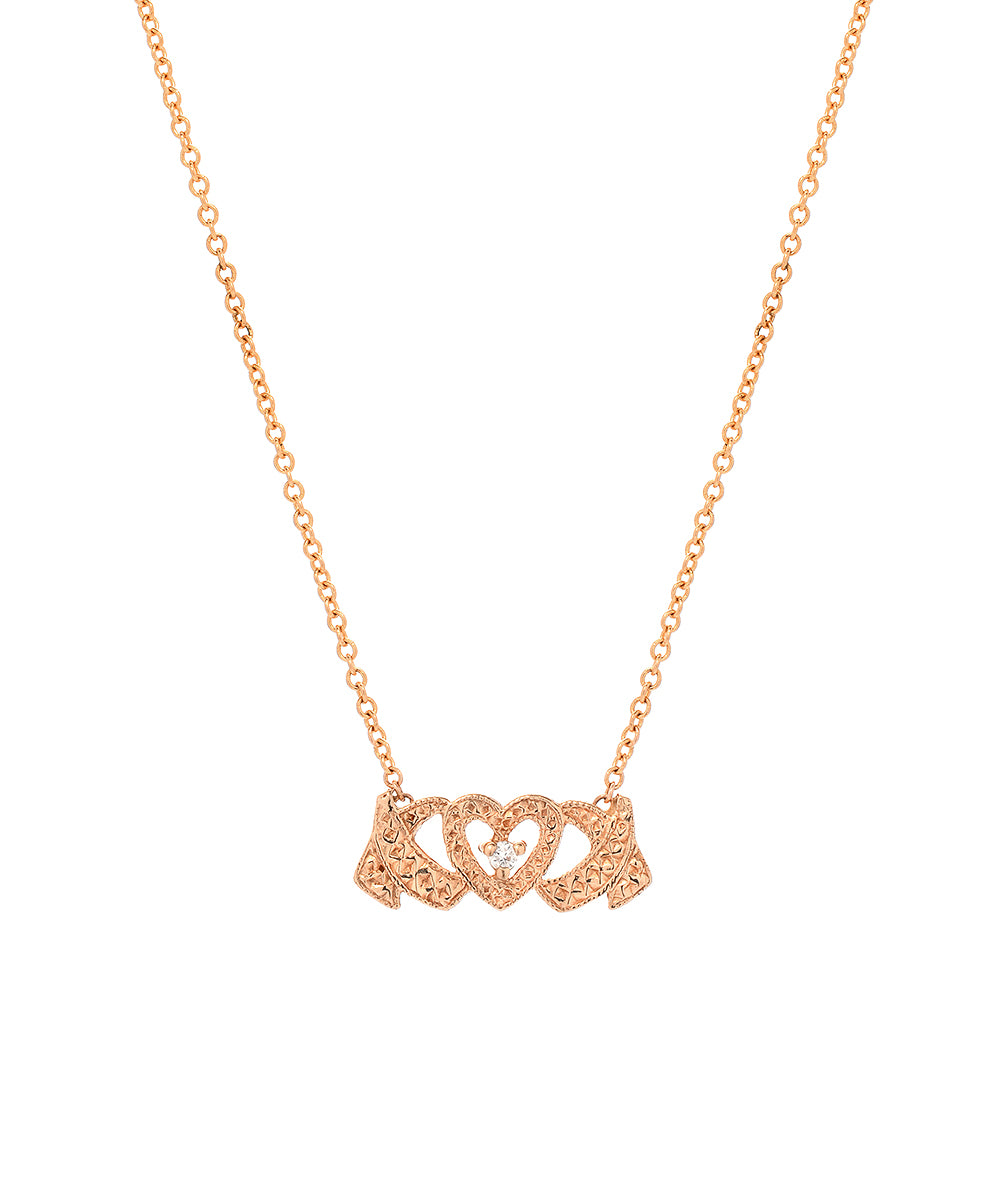 The 14 Karat Gold and Diamond Hugs and Kisses Necklace features a delicate chain with a central pendant of two interlocking hearts in a ribbon design, embellished with small sparkling diamonds.