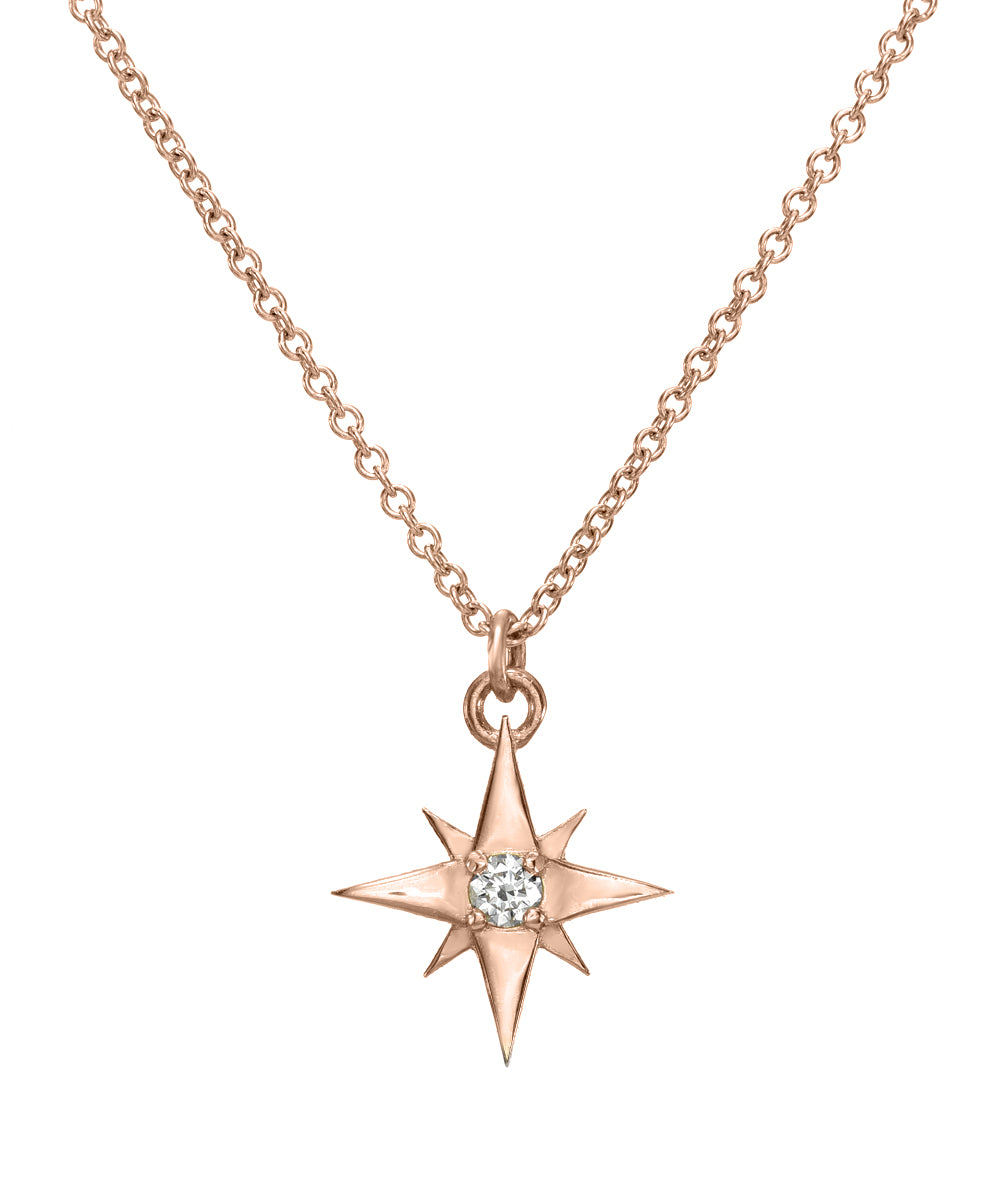 The 14K Gold Lucky North Star Diamond Pendant Necklace in rose gold features an eight-pointed star-shaped pendant with a central round diamond—an elegant piece of celestial jewelry.