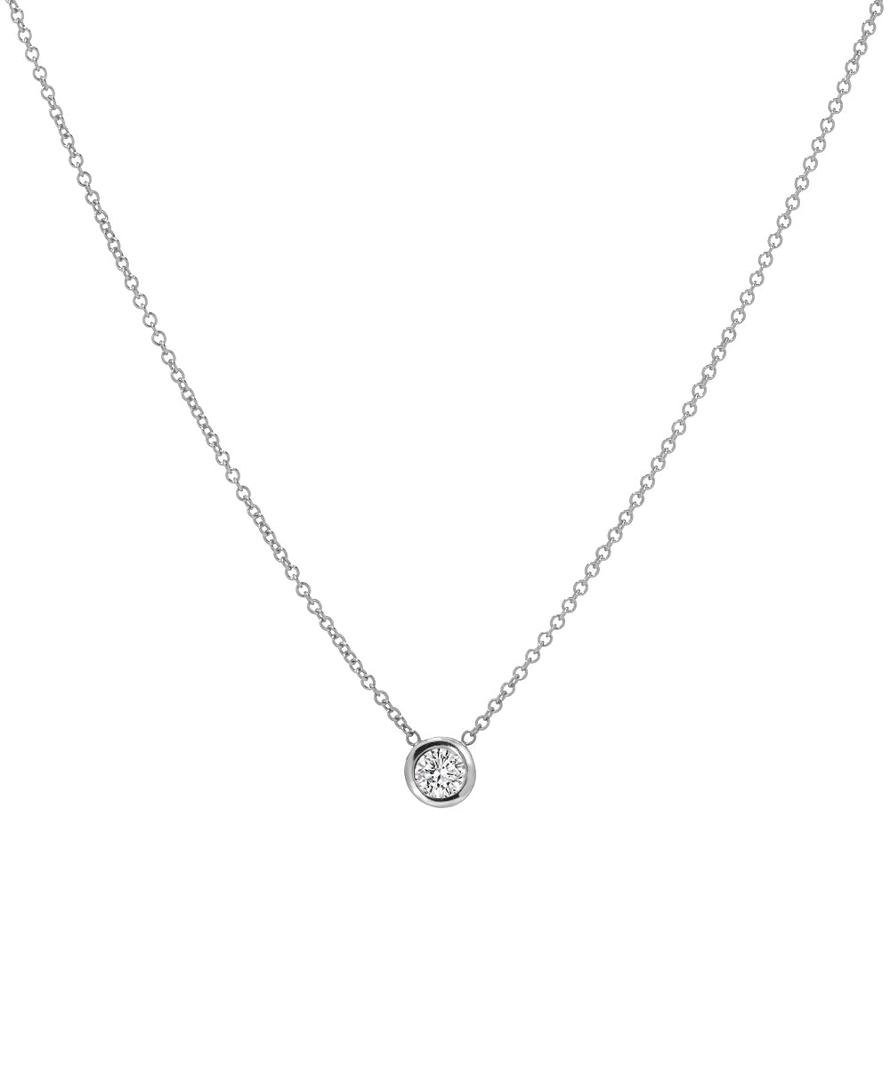 The 14KT White Gold 3 mm Bezel Solitaire Necklace features a delicate design with a single round diamond pendant set in a simple bezel at the center.