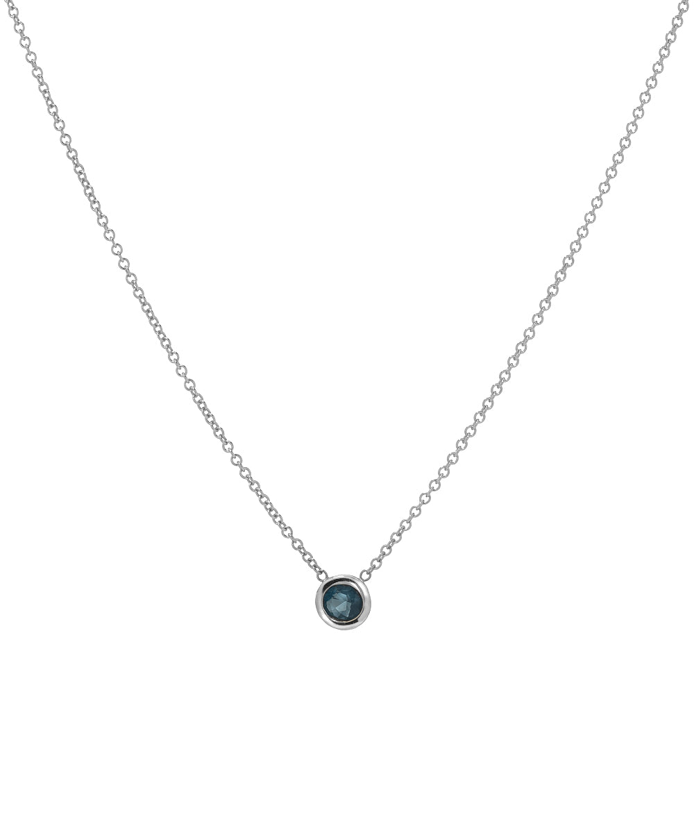 A 14KT white gold necklace featuring a 3 mm round solitaire gemstone in a simple bezel setting on a fine chain.