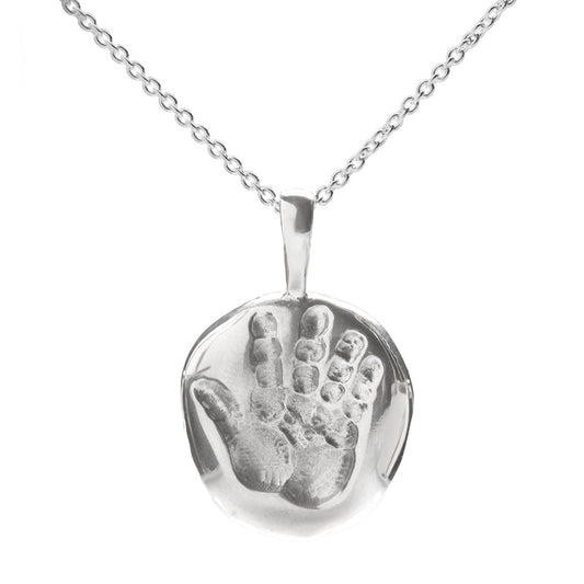 The Sterling Silver Baby Handprint Pendant Necklace features a round pendant embossed with a child’s handprint, making it an ideal sentimental push gift for new moms.
