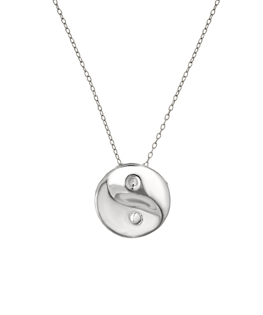 The Sterling Silver Yin Yang Pendant Necklace features a fine chain and a round, abstract pendant with smooth, wavy textures and two small cutouts—a modern piece of spiritual jewelry.