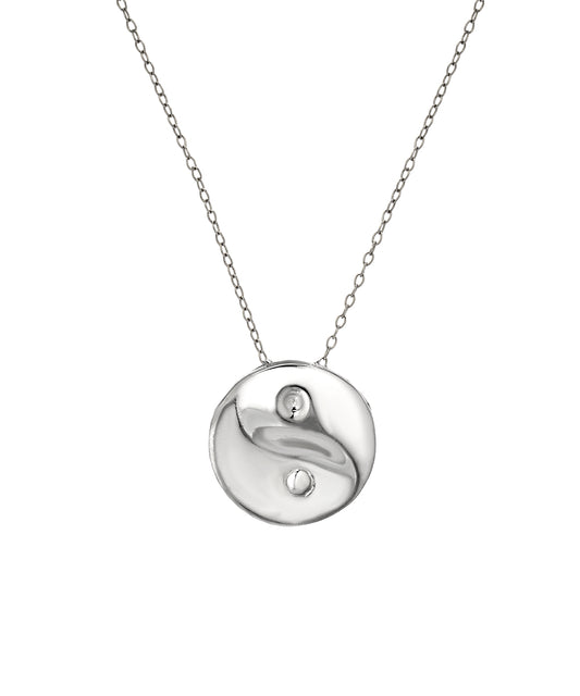 The Sterling Silver Yin Yang Pendant Necklace features a fine chain and a round, abstract pendant with smooth, wavy textures and two small cutouts—a modern piece of spiritual jewelry.