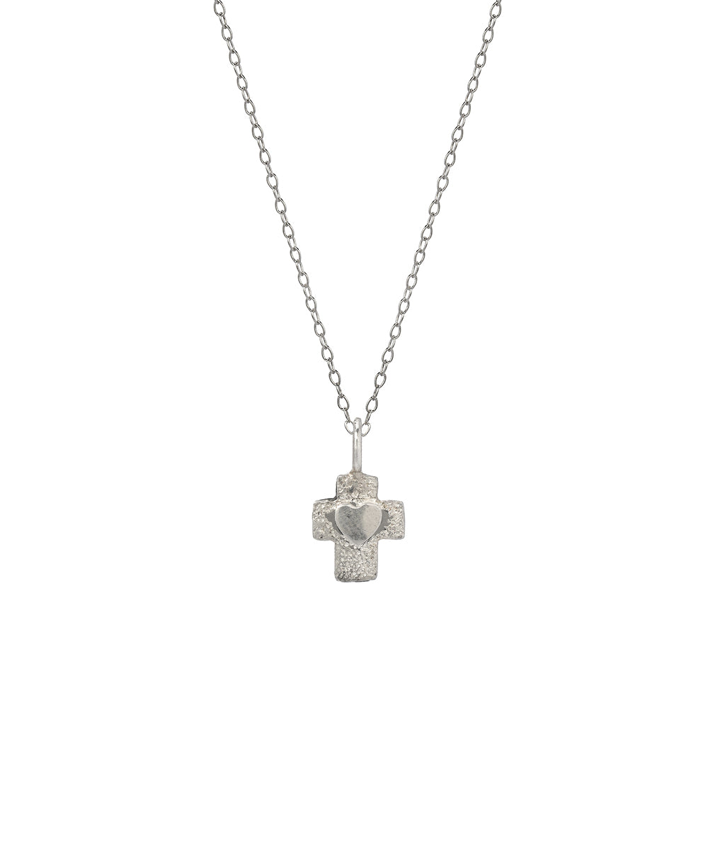The Sterling Silver Heart in Cross Pendant Necklace features a textured cross with a raised heart at the center, displayed on a plain white background—an elegant and meaningful piece of faith jewelry.
