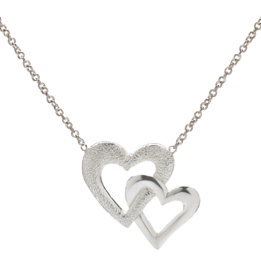 The Sterling Silver Double Heart Necklace, 18", features two interlocking hearts—one textured and one polished—in 925 sterling silver, elegantly suspended from a delicate chain against a white background.