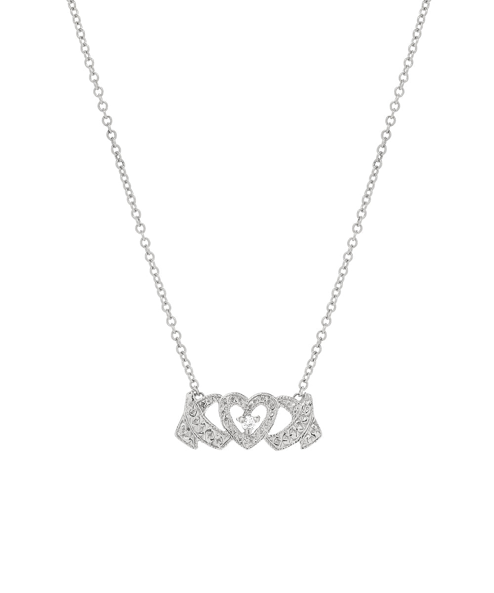 A 14 Karat Gold and Diamond Hugs and Kisses Necklace featuring a central XOXO pendant with two intertwined hearts adorned with sparkling stones, all on a fine chain.