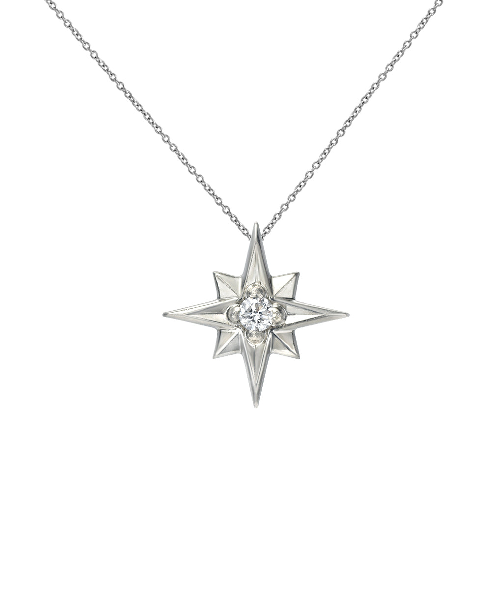 The 14K Gold North Star Diamond Pendant Necklace showcases an eight-pointed star with a sparkling diamond center, suspended on a fine chain and presented against a white background.