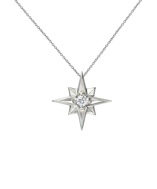 The 14K Gold North Star Diamond Pendant Necklace showcases an eight-pointed star with a sparkling diamond center, suspended on a fine chain and presented against a white background.