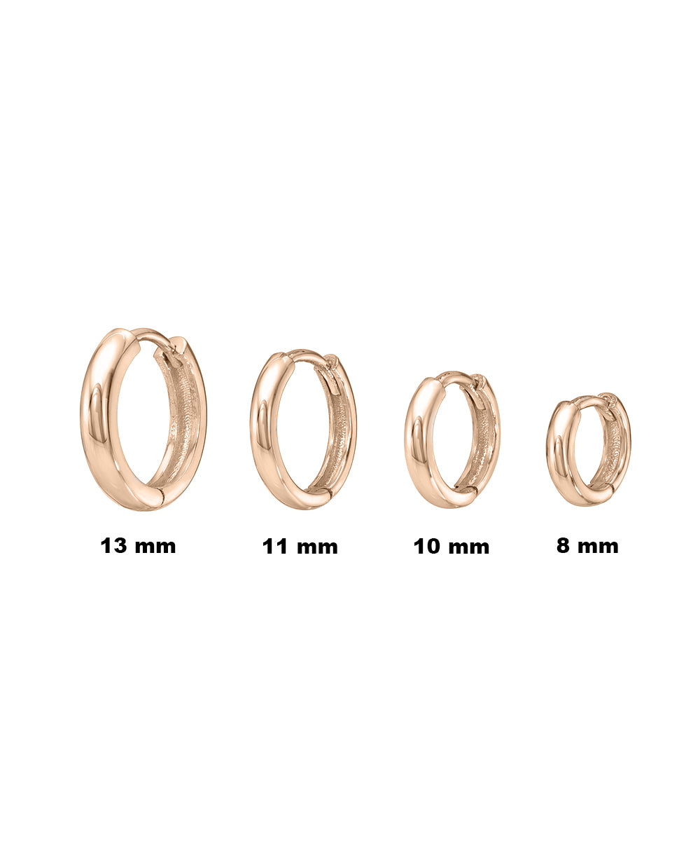 Four 14 Karat Gold 2 mm Wide Huggie Hoops in sizes 8 mm, 10 mm, 11 mm, and 13 mm are shown from right to left on a white background—a classic fine jewelry staple.