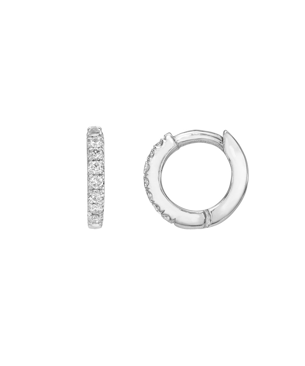 The 14 Karat Yellow Gold Diamond Pave Huggie Hoops are shown; one displays a row of sparkling natural VS1 diamonds, while the other highlights its slim profile and sleek gold finish.